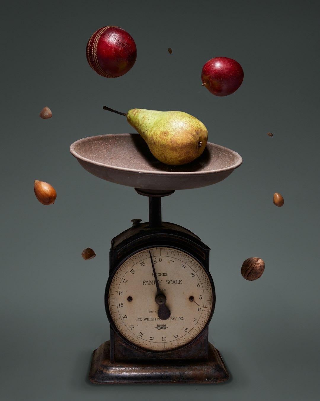 Vintage scale with a pear and assorted nuts floating.