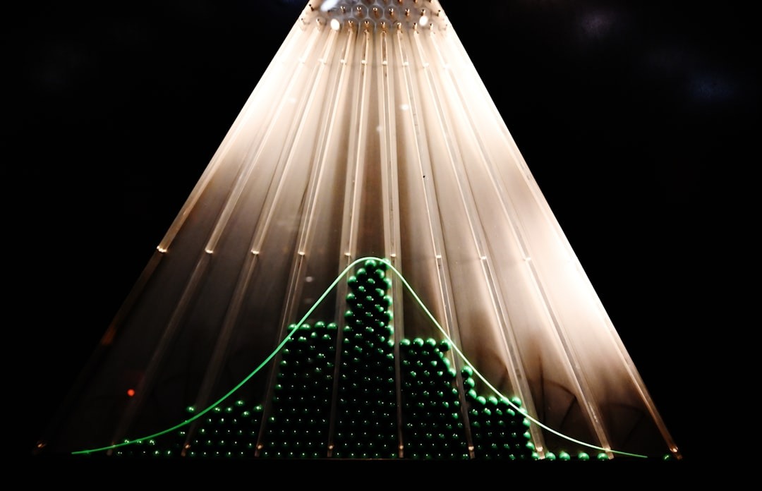 Green beads in a Galton board form a bell curve.